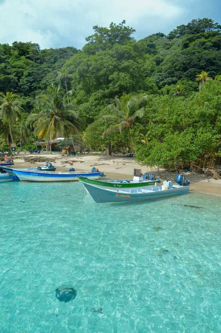 Lanchas ancladas en las aguas cristalinas turquesas de la playa La Miel en Capurganá