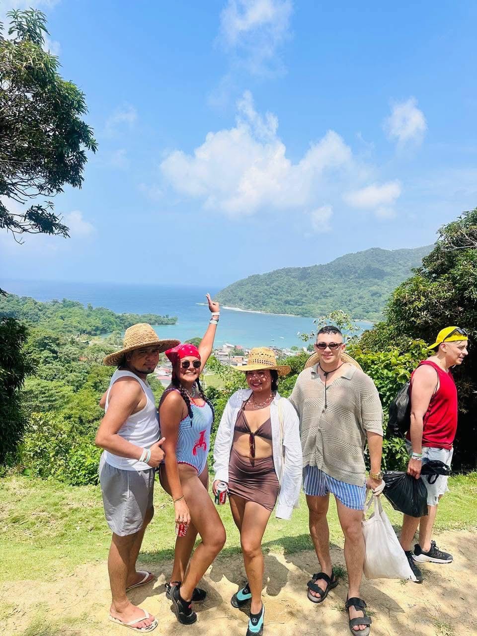 Grupo de turistas posando en un mirador con vista panorámica de la bahía de Capurganá