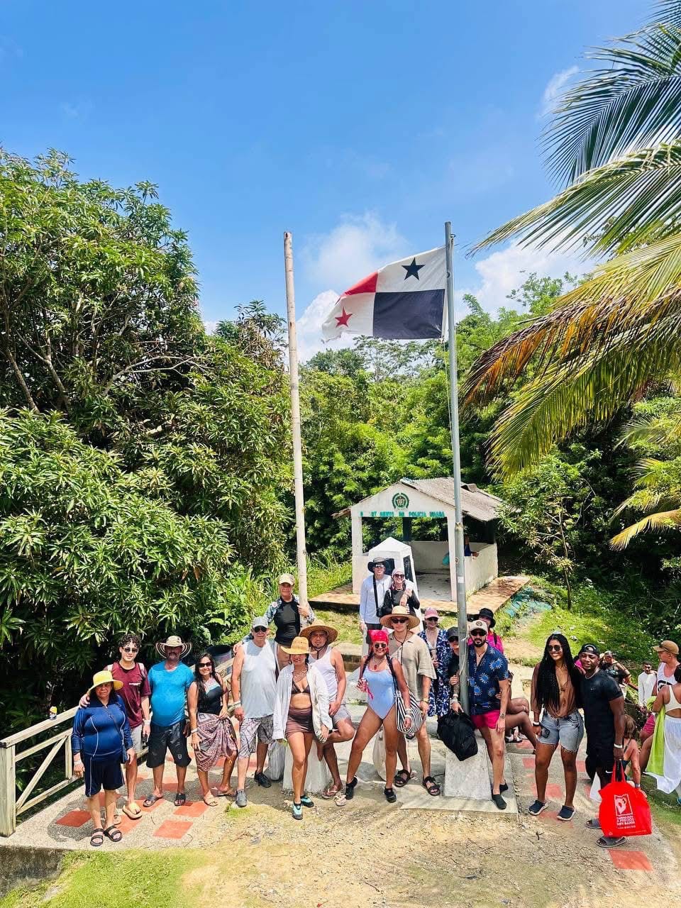 Grupo de turistas frente a la bandera de Panamá en la frontera con Capurganá