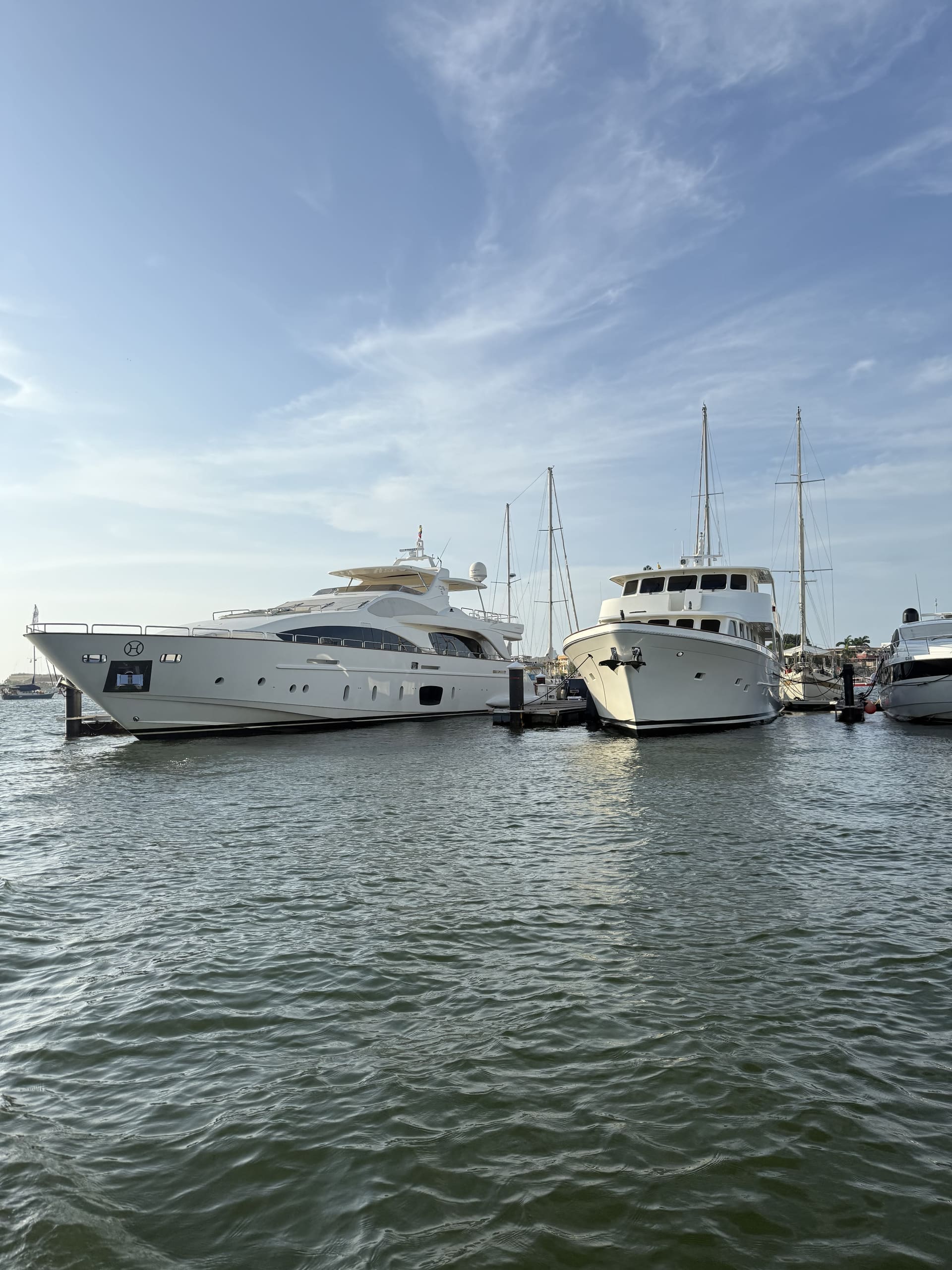 Yates y veleros amarrados en la marina de Cartagena con el atardecer de fondo