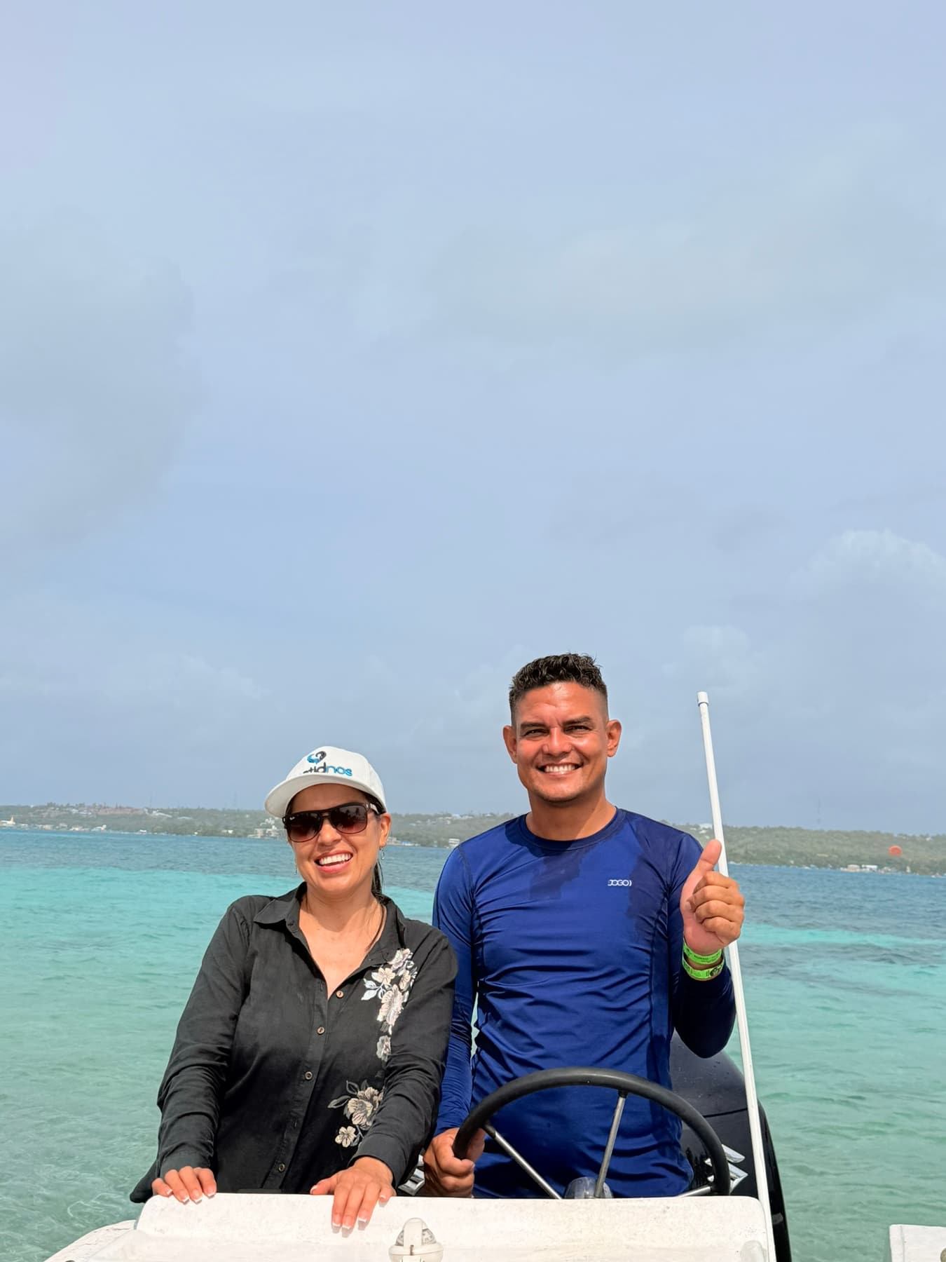 Pareja de turistas en la playa con el mar turquesa de San Andrés de fondo