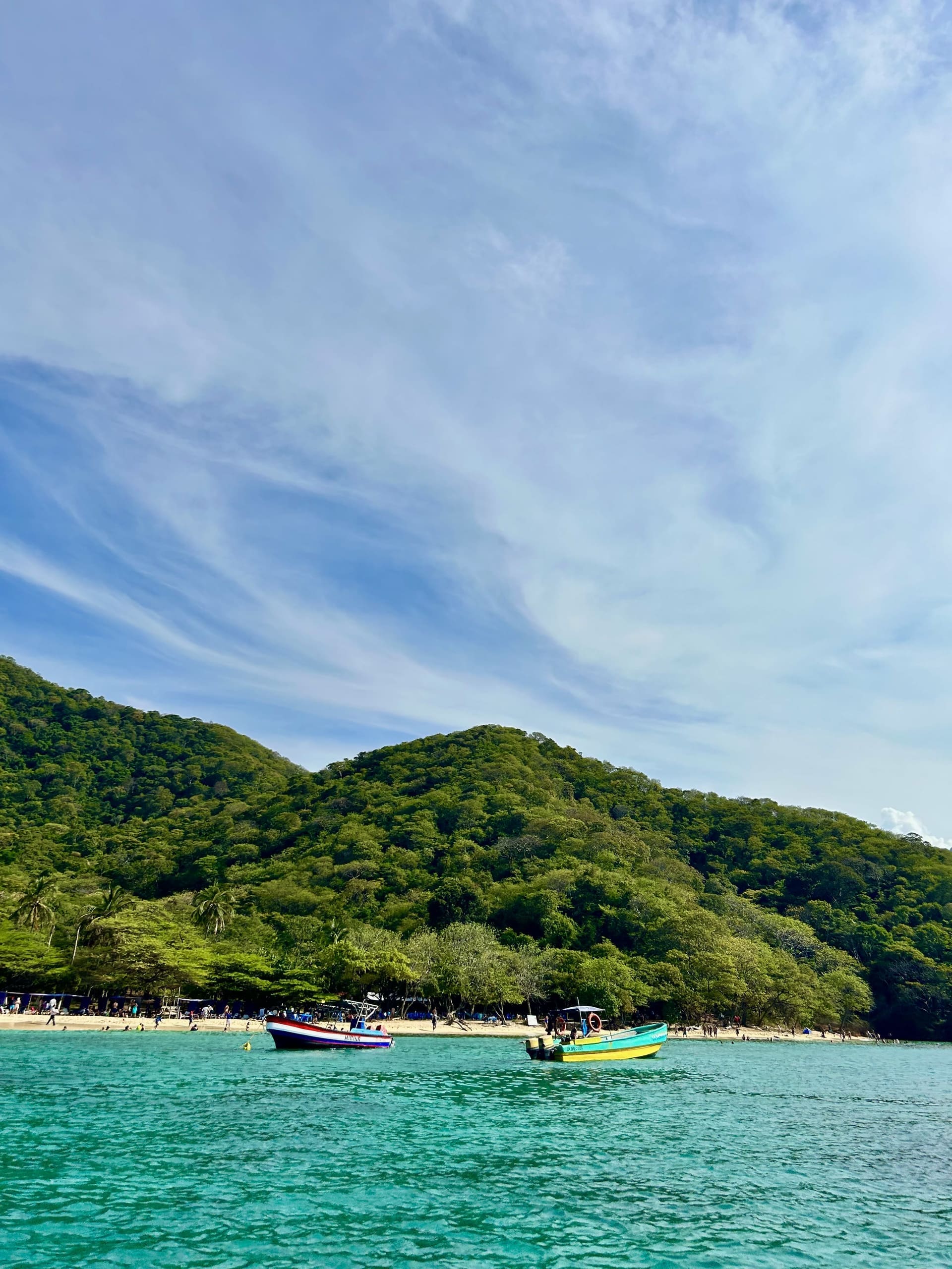 Lanchas turísticas ancladas en una cala de aguas turquesas del Parque Tayrona, cerca de Santa Marta