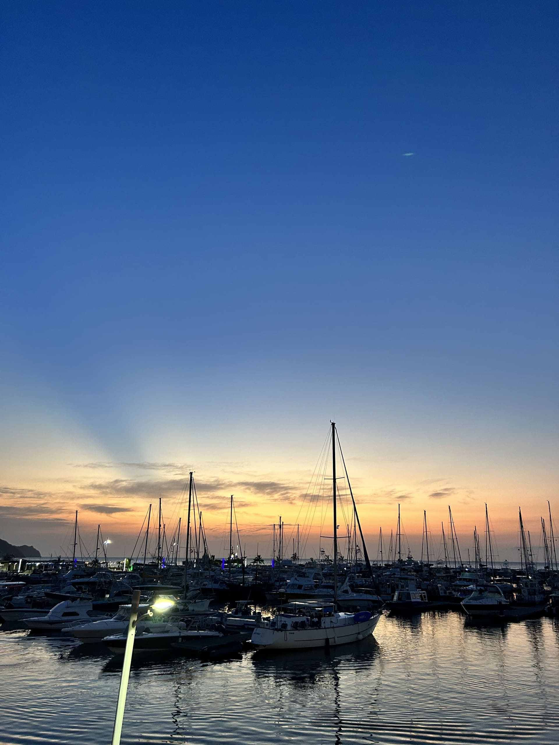 Veleros en la Marina Internacional de Santa Marta durante el atardecer, con el cielo naranja de fondo