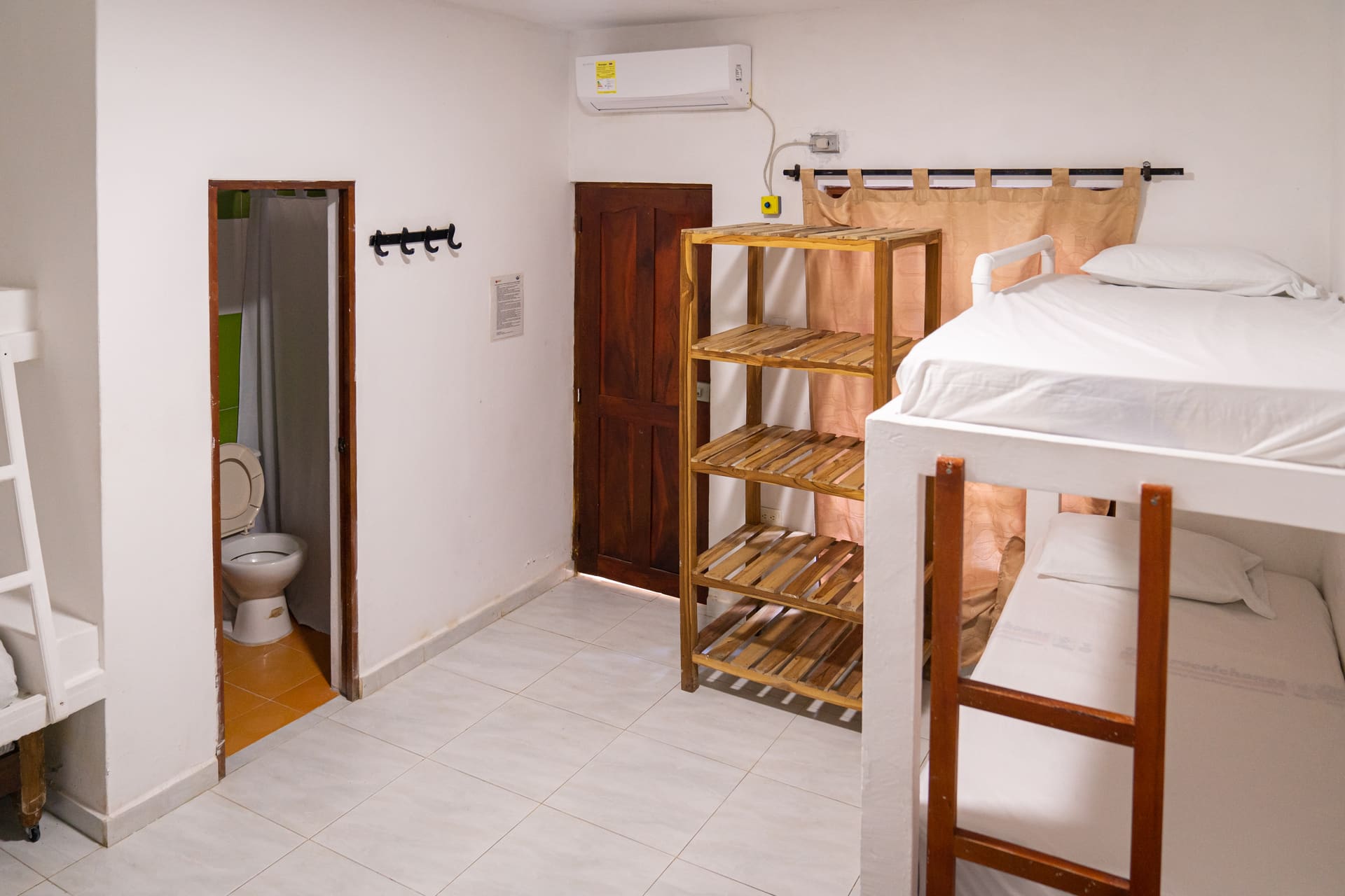 Habitación de Apartahotel Acapulco con baño privado, estante de madera y litera