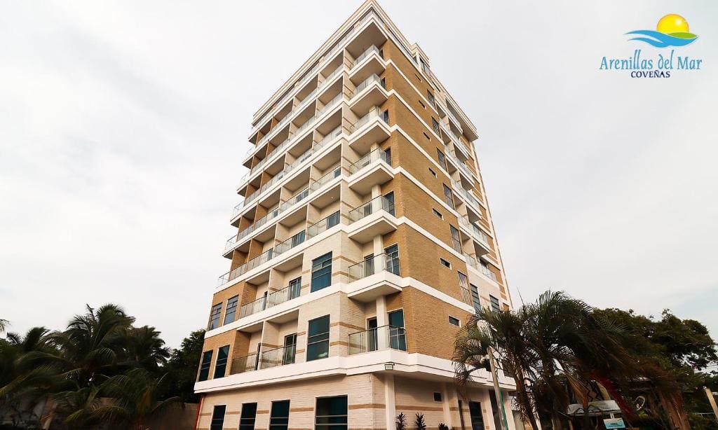 Fachada del Condominio Arenillas del Mar en Coveñas, edificio frente al mar entre palmeras