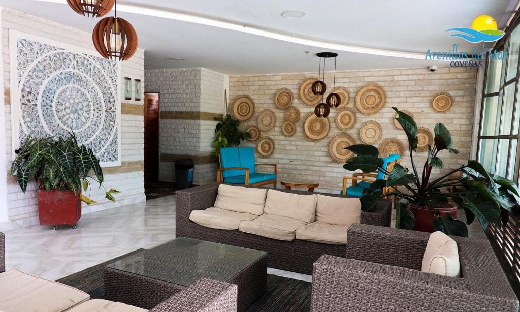 Lobby y sala de espera del Condominio Arenillas del Mar, con muebles y decoración en madera