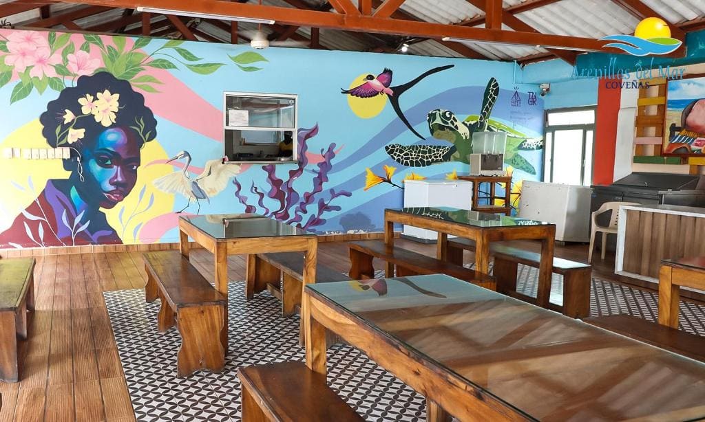 Zona de comedor del Condominio Arenillas del Mar, con mural de fauna marina en la pared