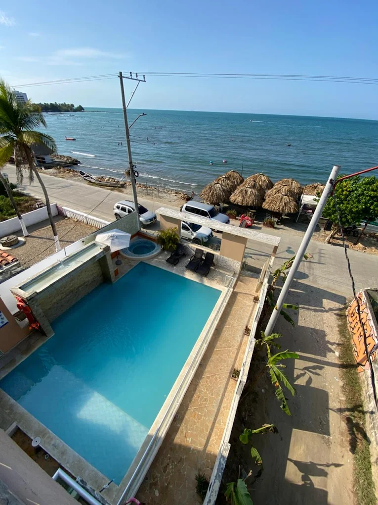 Vista aérea de la piscina de Hotel Grand Cove junto a la playa y las palapas vecinas