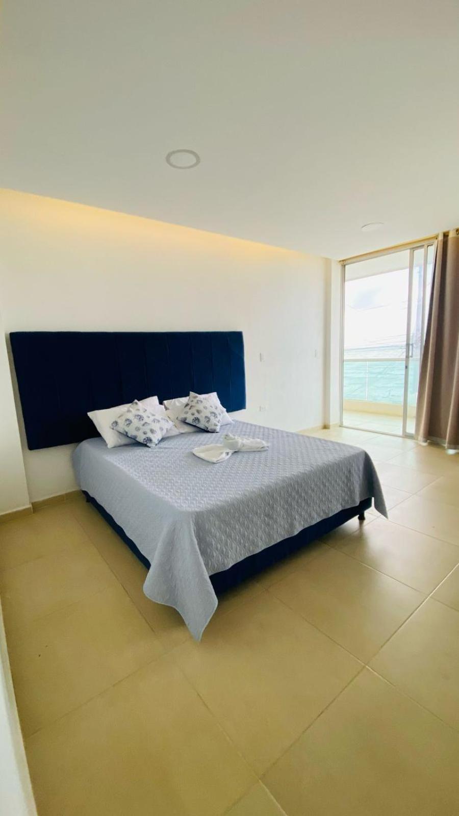 Habitación de Hotel Grand Cove con cama doble, cabecero azul y vista al mar