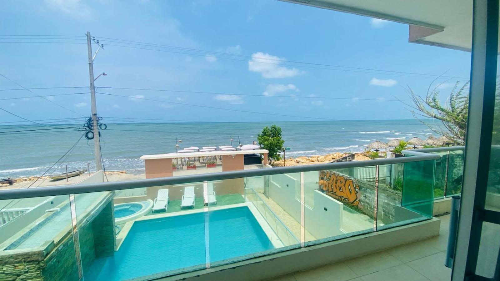 Vista desde el balcón de una habitación de Hotel Grand Cove hacia la piscina y el mar
