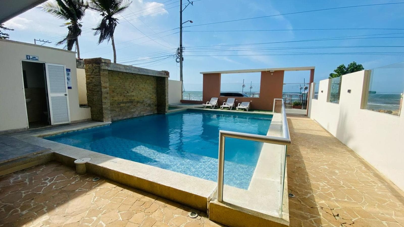Piscina de Hotel Grand Cove a nivel de calle, junto a un muro con cascada decorativa