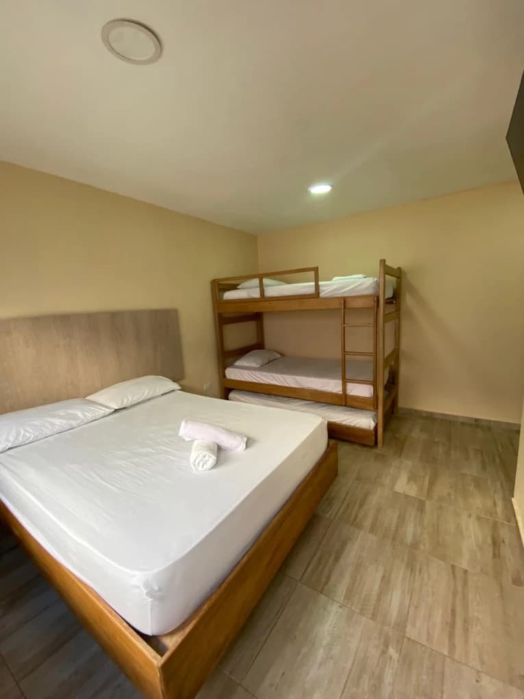 Habitación de Hotel Grand Cove con cama doble y litera en tonos de madera