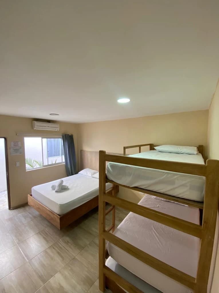 Habitación de Hotel Grand Cove con cama doble, litera y aire acondicionado junto a la ventana