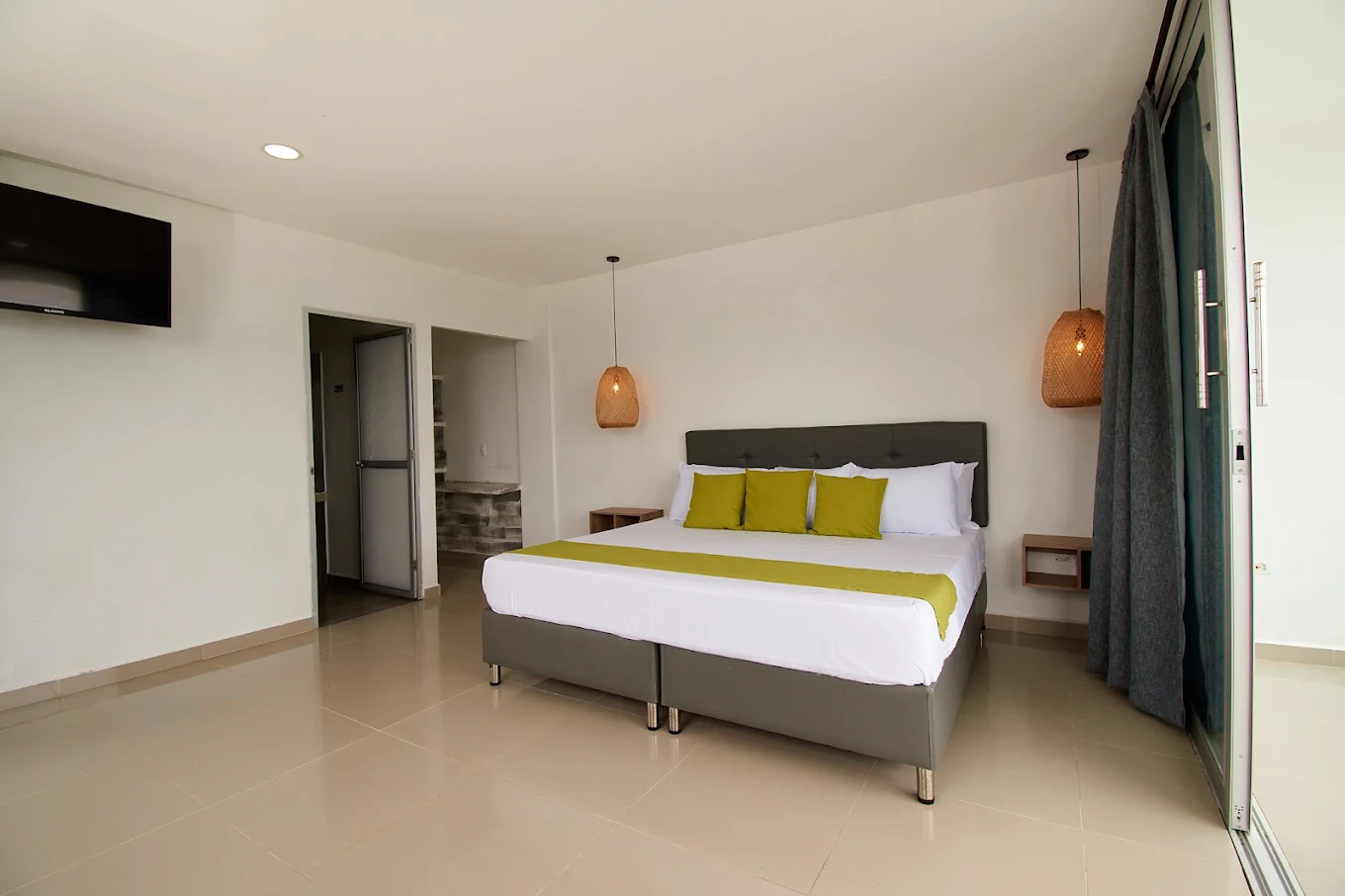 Habitación con cama king y cojines verdes
