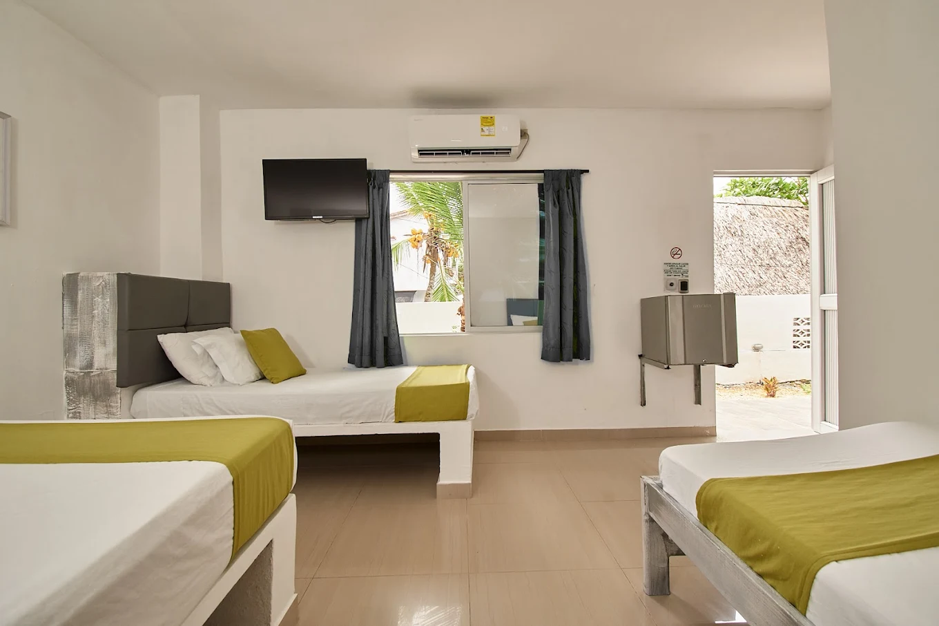 Habitación con varias camas y aire acondicionado