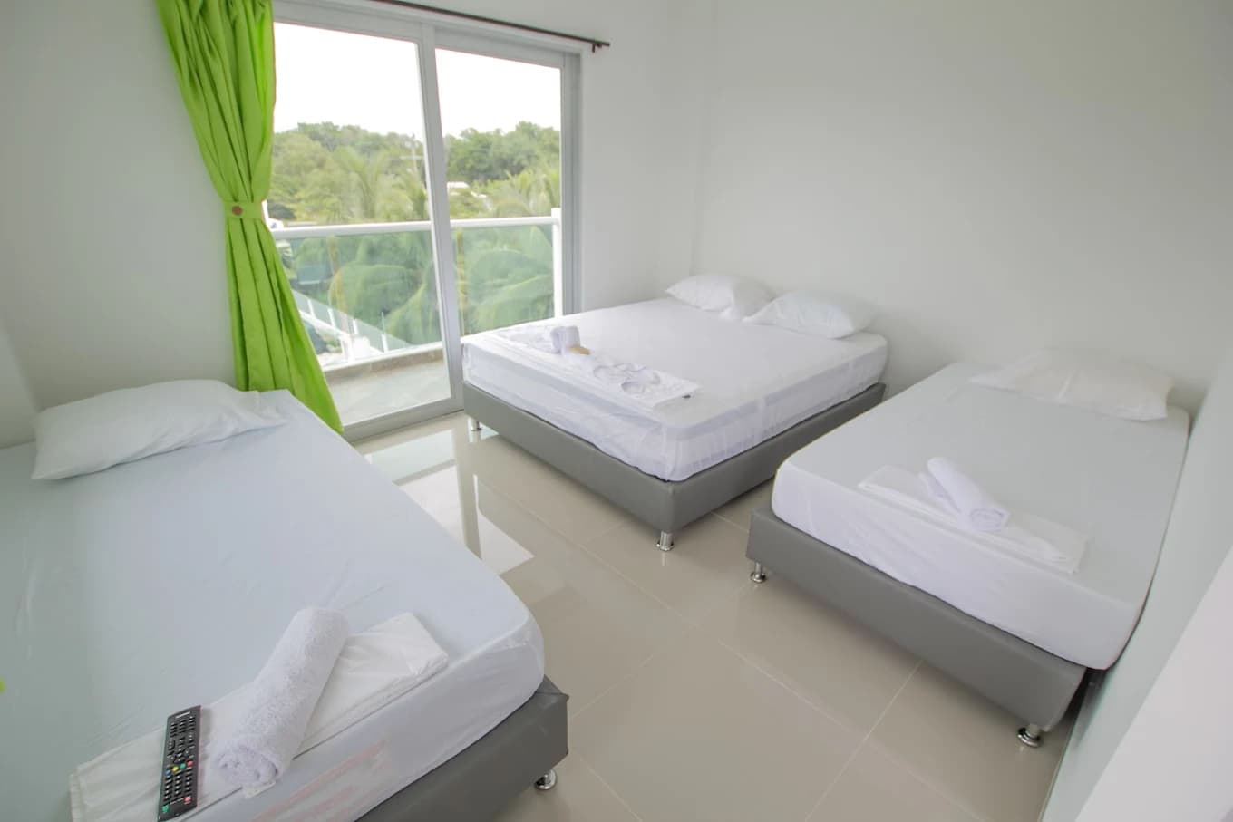 Habitación con camas dobles y cortina verde