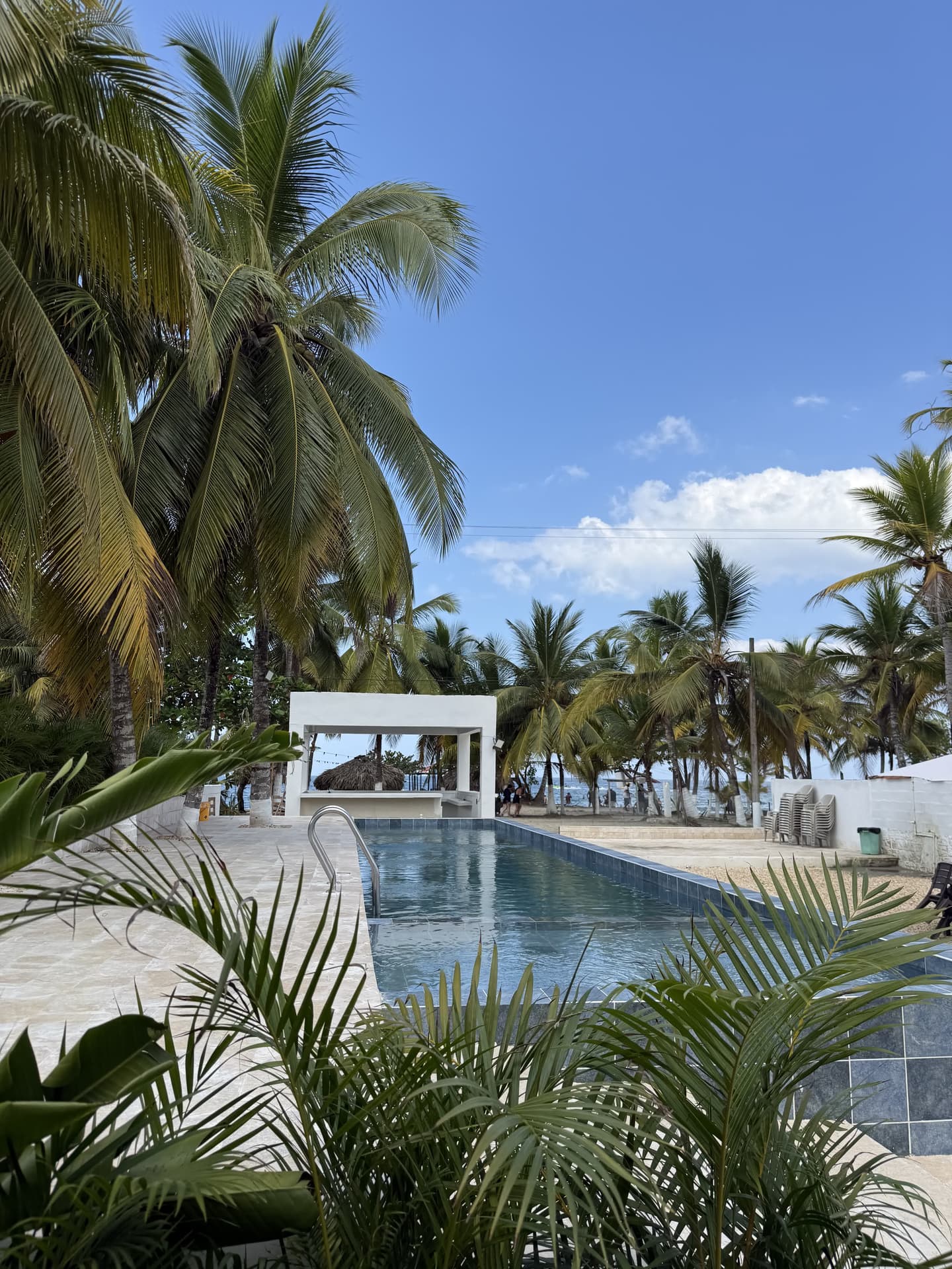 Vista panorámica de la piscina y las cabañas blancas de Hotel Kiimala