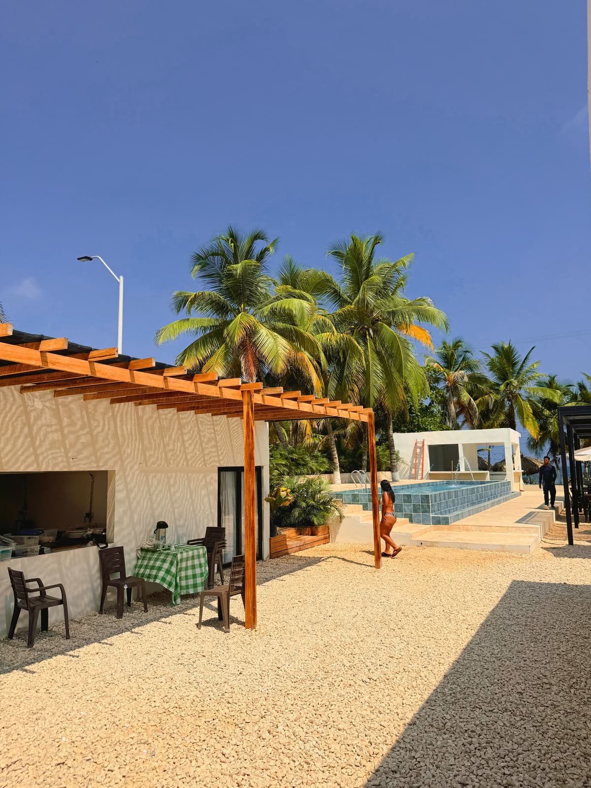 Terraza con pérgola junto a la piscina de Hotel Kiimala, zona social frente al mar
