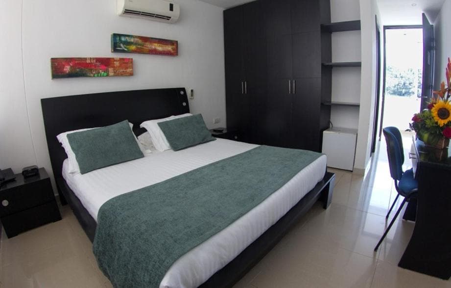 Habitación moderna de Hotel Tayrona Rodadero con muebles en tonos oscuros