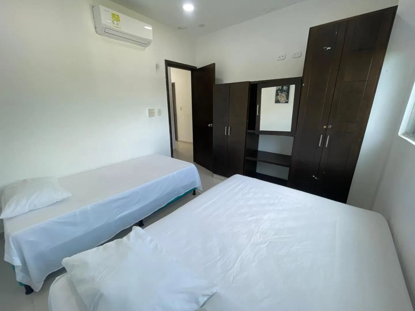 Habitación múltiple de Torre Blanca con closet de madera oscura y espejo
