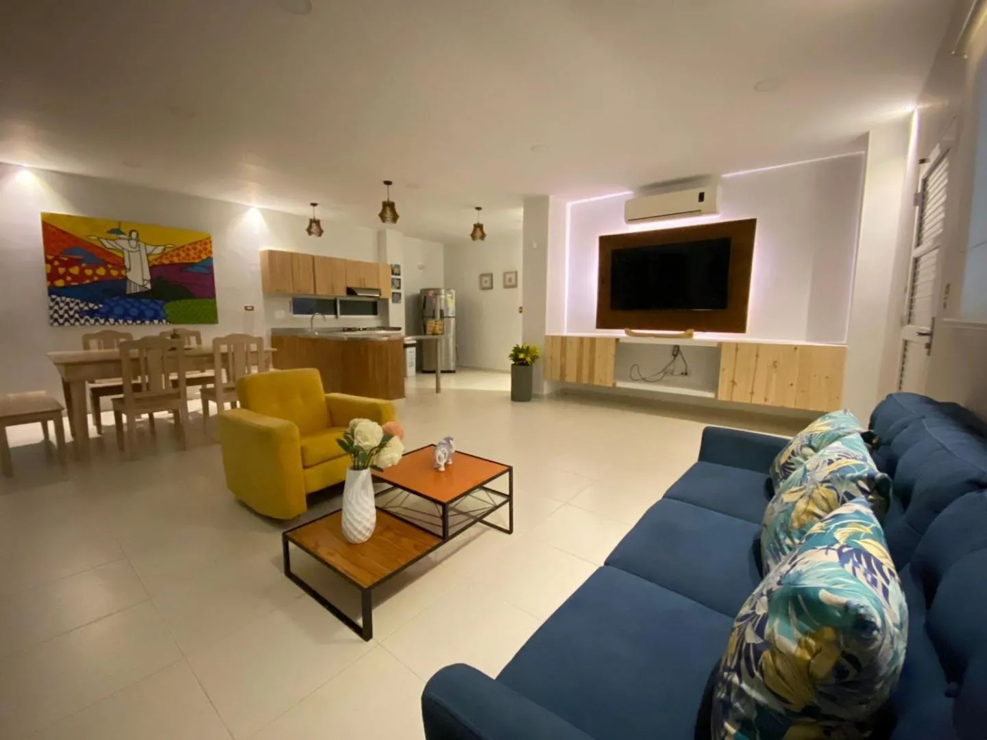 Sala comedor de Torre Blanca con cocina integrada, sofá azul y comedor de madera