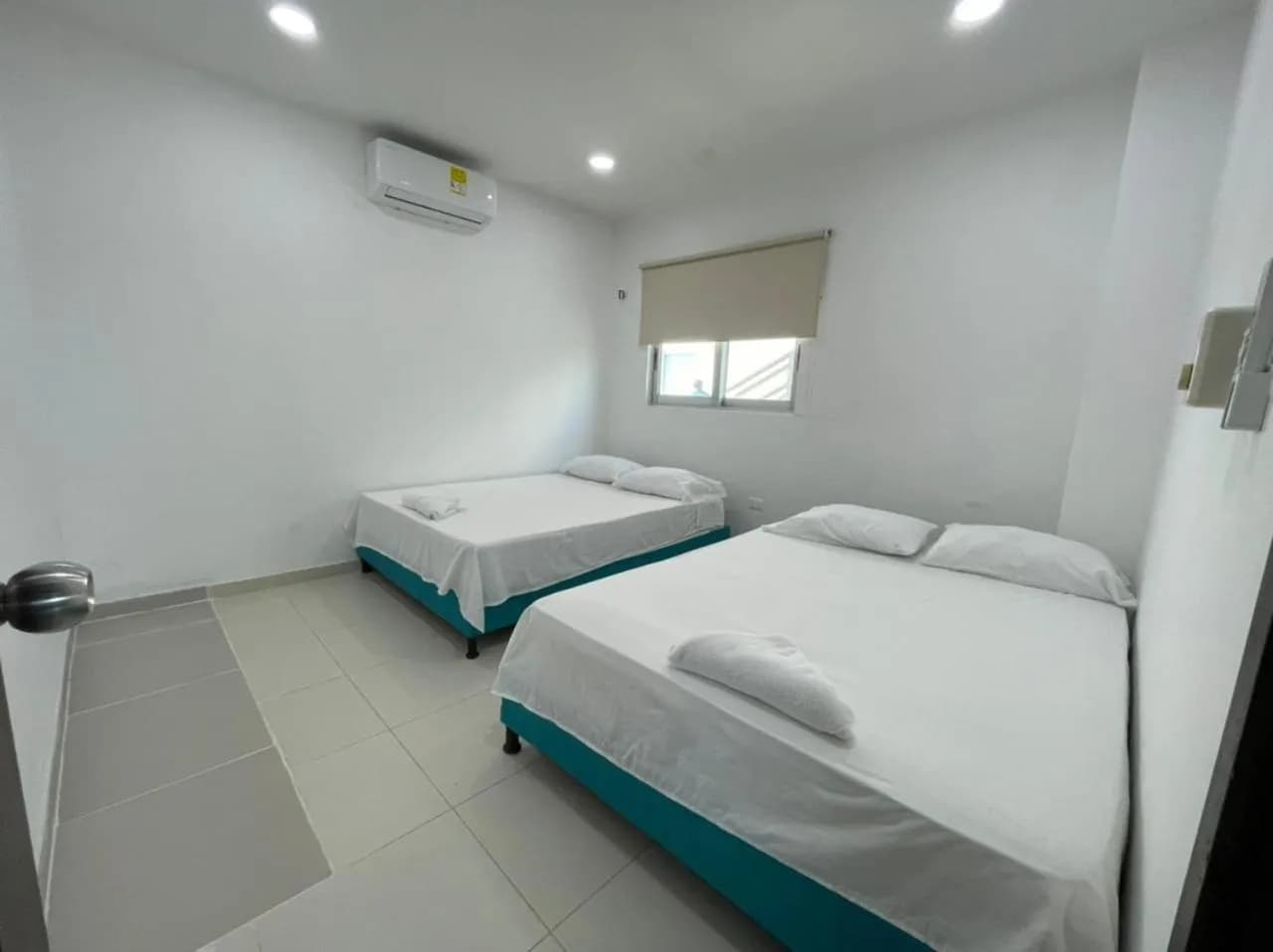 Habitación con dos camas dobles y ventana en Torre Blanca